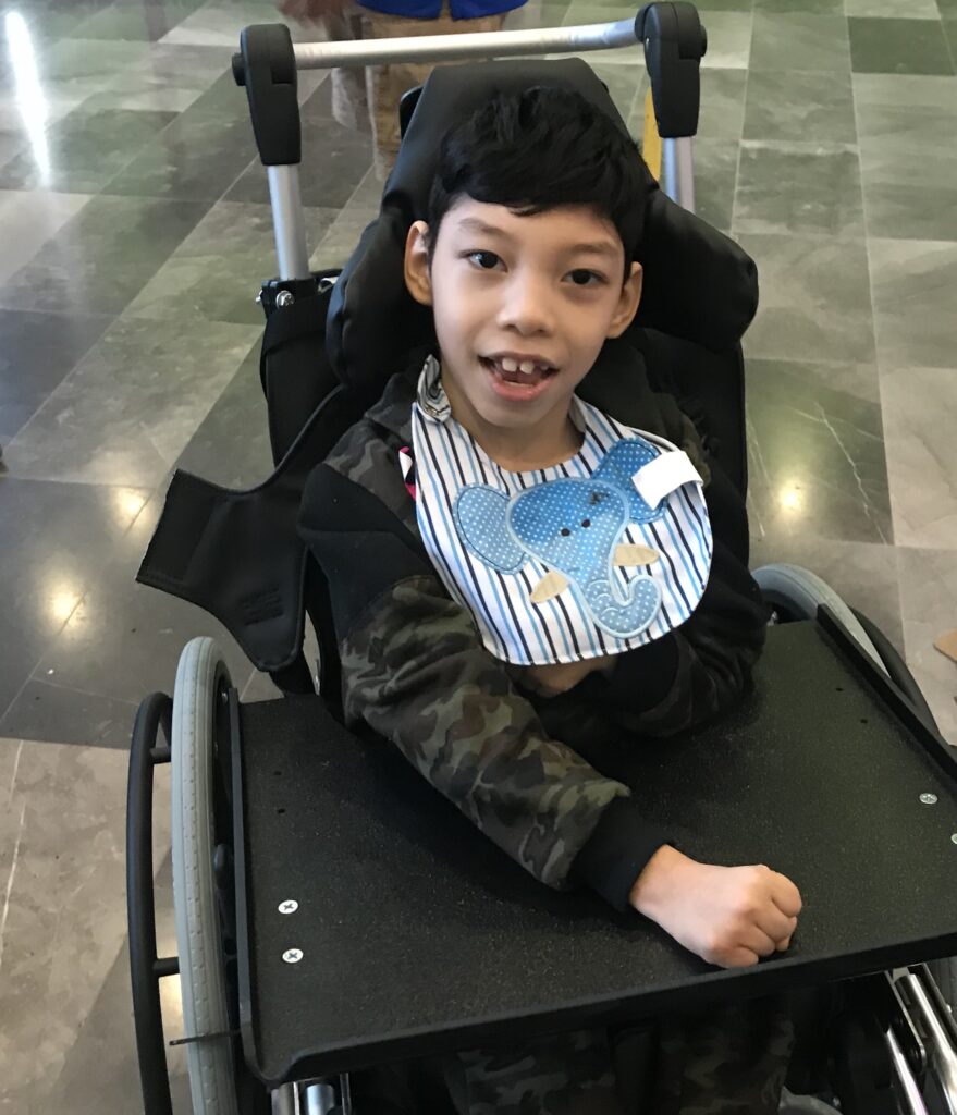 Child smiling in their new wheelchair