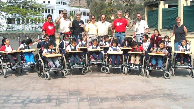 Volunteers and children in new wheelchairs