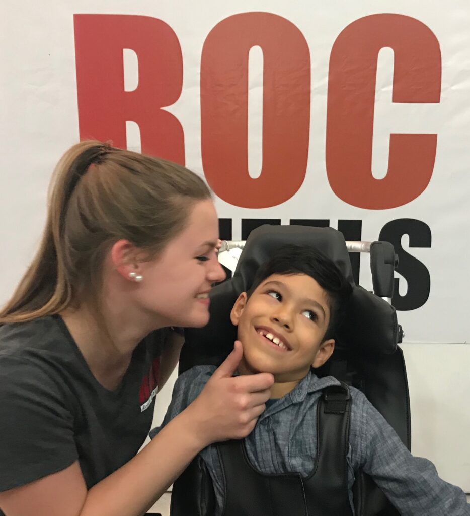volunteer with young boy in his new wheelchair